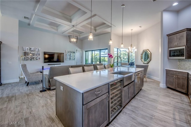 3726 Ceitus Pkwy, Cape Coral, FL 33991 - kitchen with a sink, wine cooler, baseboards, light wood-style flooring, and light countertops