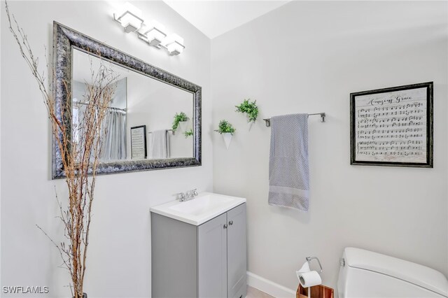 5397 25th Ave SW, Naples, FL 34116 - bathroom featuring toilet, vanity, baseboards, and a shower with shower curtain