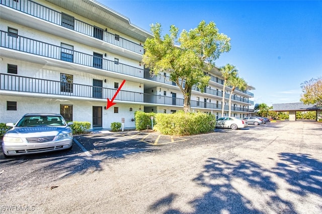 600 Neapolitan Way Unit 153, Naples, FL 34103 - view of building exterior with uncovered parking