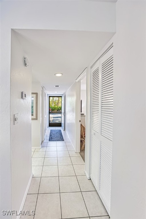 600 Neapolitan Way Unit 153, Naples, FL 34103 - corridor with light tile patterned floors and baseboards