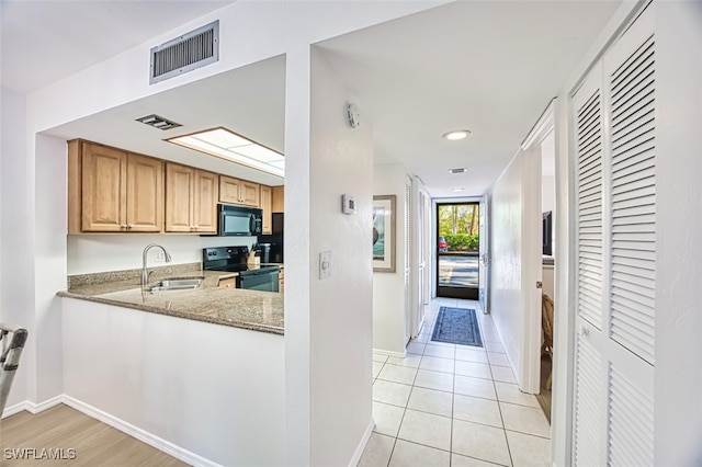 600 Neapolitan Way Unit 153, Naples, FL 34103 - kitchen with black appliances, stone counters, light tile patterned flooring, and recessed lighting