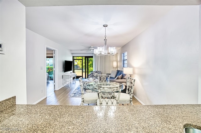 600 Neapolitan Way Unit 153, Naples, FL 34103 - dining room featuring wood finished floors and a chandelier