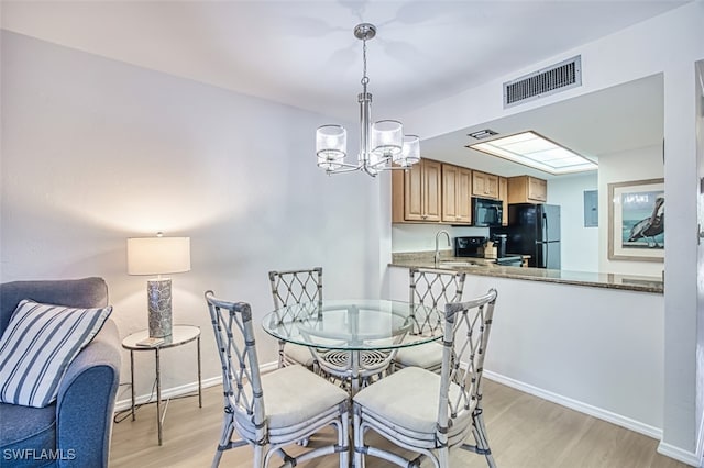 600 Neapolitan Way Unit 153, Naples, FL 34103 - dining area with light wood finished floors, a chandelier, and electric panel