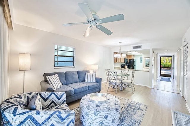600 Neapolitan Way Unit 153, Naples, FL 34103 - living room featuring light wood-type flooring, ceiling fan, and a chandelier
