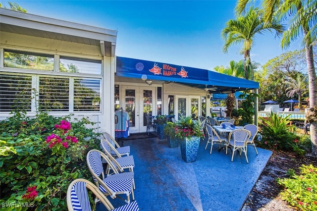 600 Neapolitan Way Unit 153, Naples, FL 34103 - view of patio / terrace featuring french doors
