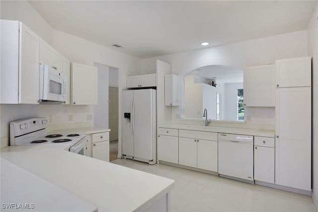 14541 Daffodil Dr Unit 1702, Fort Myers, FL 33919 - kitchen featuring white appliances, arched walkways, a sink, light countertops, and white cabinetry