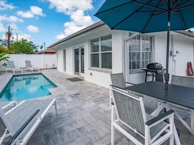 698 99th Ave N, Naples, FL 34108 - view of swimming pool with a patio area, a fenced backyard, outdoor dining space, and area for grilling