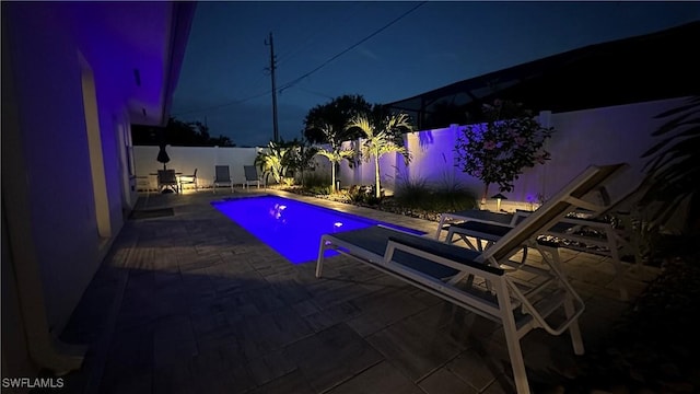 698 99th Ave N, Naples, FL 34108 - pool at night with a patio area and a fenced backyard