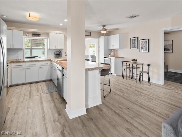 698 99th Ave N, Naples, FL 34108 - kitchen featuring appliances with stainless steel finishes, light wood-type flooring, a breakfast bar, plenty of natural light, and recessed lighting