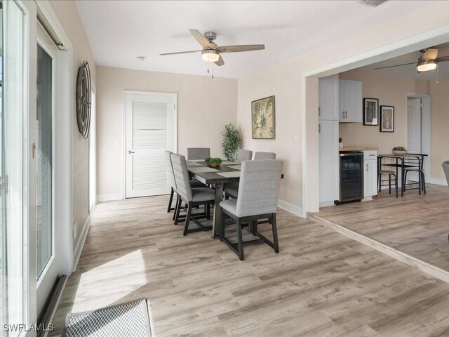 698 99th Ave N, Naples, FL 34108 - dining area with wine cooler, a ceiling fan, baseboards, and light wood-style flooring