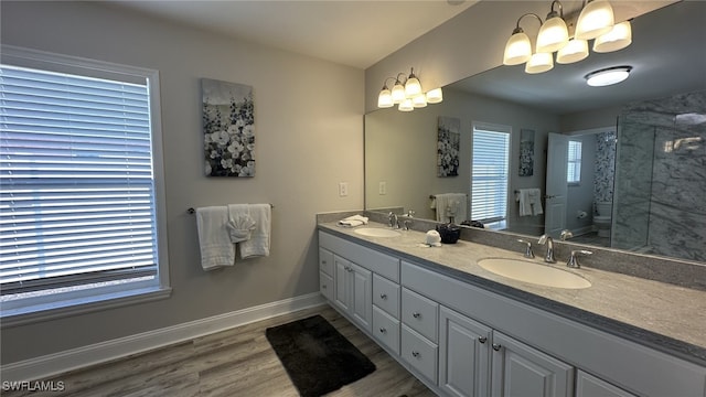 698 99th Ave N, Naples, FL 34108 - bathroom featuring toilet, wood finished floors, double vanity, a shower, and a chandelier