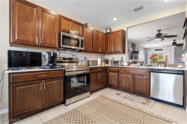 18 SW 19th Ter, Cape Coral, FL 33991 - kitchen featuring stainless steel appliances, tasteful backsplash, a ceiling fan, light tile patterned floors, and light countertops