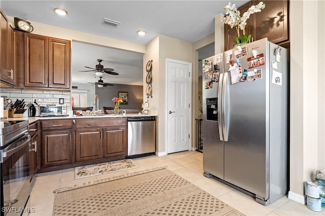 18 SW 19th Ter, Cape Coral, FL 33991 - kitchen featuring stainless steel appliances, a sink, ceiling fan, light tile patterned flooring, and light countertops