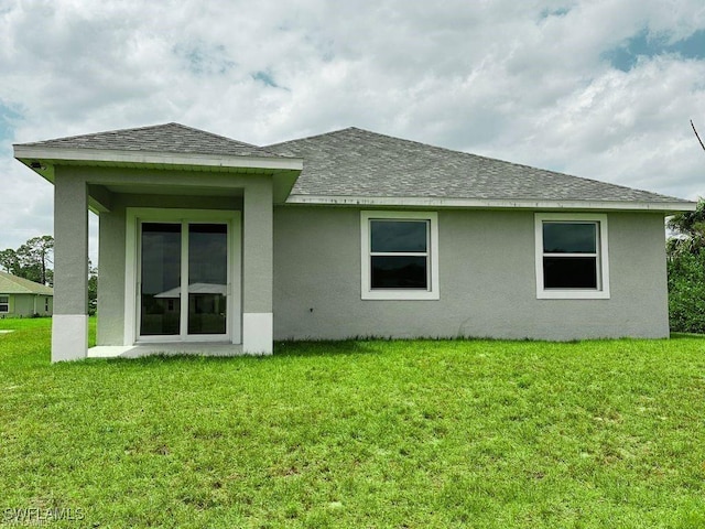 6007 Kumquat Cir, Labelle, FL 33935 - back of house featuring roof with shingles, stucco siding, and a lawn