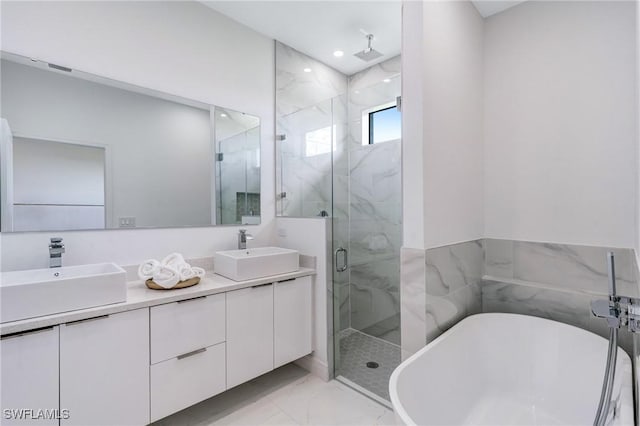 9018 W Castle Cir, Labelle, FL 33935 - bathroom with marble look tiles, a marble finish shower, a freestanding bath, double vanity, and recessed lighting