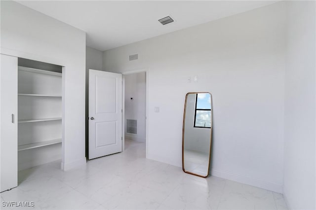 9018 W Castle Cir, Labelle, FL 33935 - unfurnished bedroom with marble look tile flooring, a closet, and baseboards