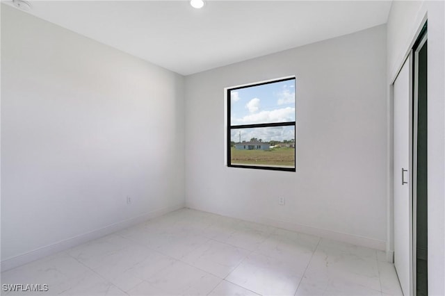 9018 W Castle Cir, Labelle, FL 33935 - empty room featuring light marble finish floors, recessed lighting, and baseboards