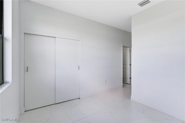 9018 W Castle Cir, Labelle, FL 33935 - unfurnished bedroom with marble finish floors, a closet, and baseboards