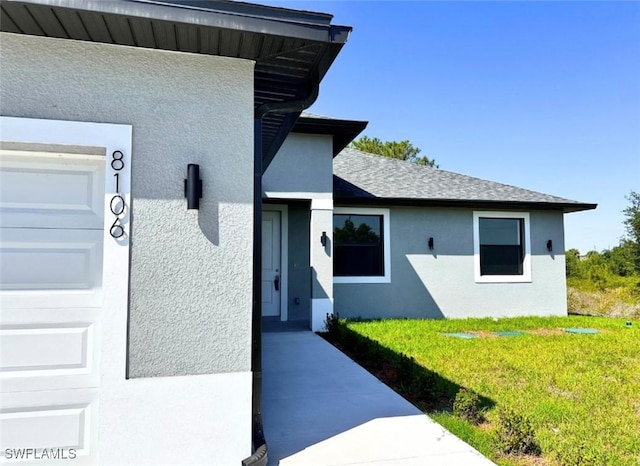 8106 Olive Ct, Labelle, FL 33935 - view of exterior entry with stucco siding and a lawn