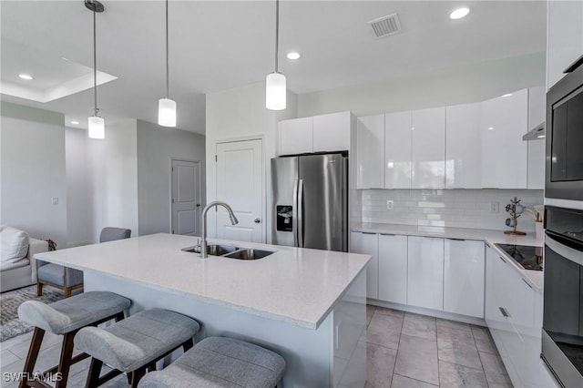2008 Hercules Rd, Labelle, FL 33935 - kitchen with a sink, stainless steel fridge, modern cabinets, white cabinetry, and a breakfast bar area