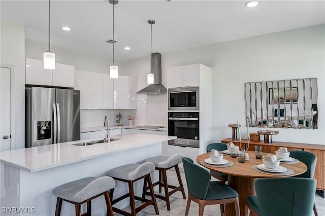 2008 Hercules Rd, Labelle, FL 33935 - kitchen with stainless steel appliances, wall chimney range hood, a sink, white cabinetry, and recessed lighting