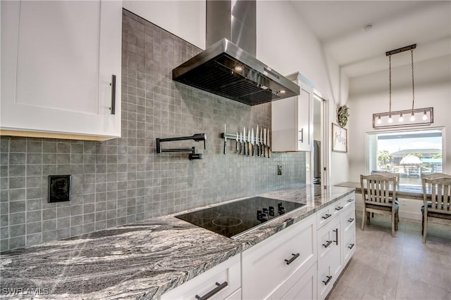 3621 NW 14th St, Cape Coral, FL 33993 - kitchen with wall chimney range hood, black electric stovetop, backsplash, light stone countertops, and white cabinetry