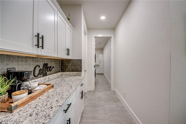 3621 NW 14th St, Cape Coral, FL 33993 - kitchen with tasteful backsplash, light stone countertops, white cabinets, baseboards, and recessed lighting