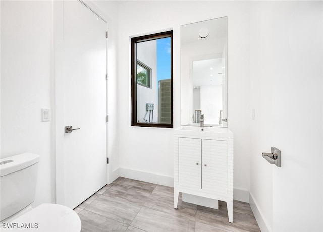 507 107th Ave N, Naples, FL 34108 - bathroom featuring toilet, vanity, and baseboards