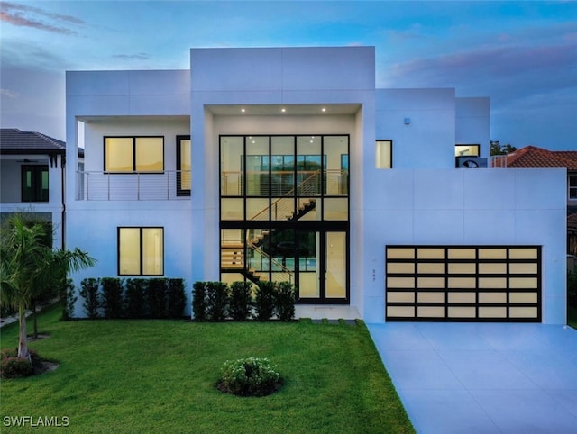 507 107th Ave N, Naples, FL 34108 - view of front facade with concrete driveway, a lawn, a garage, and stucco siding
