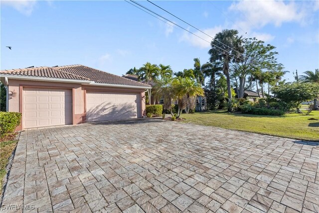 325 SE 21st St, Cape Coral, FL 33990 - view of front of property with decorative driveway, a front lawn, a garage, and a tiled roof