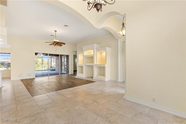 325 SE 21st St, Cape Coral, FL 33990 - unfurnished room featuring built in features, arched walkways, ceiling fan, a chandelier, and baseboards