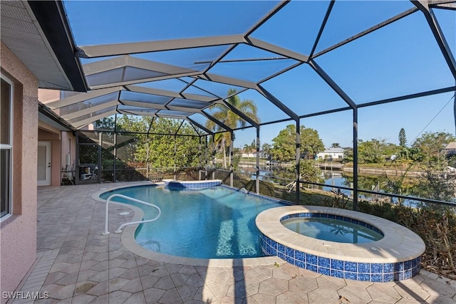 325 SE 21st St, Cape Coral, FL 33990 - view of pool featuring a patio area, a pool with connected hot tub, a lanai, and a water view