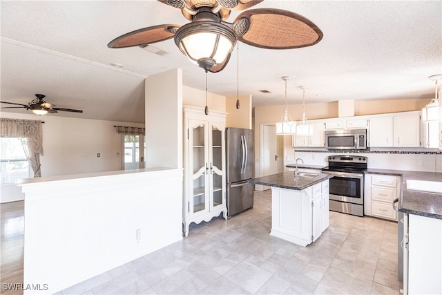 19703 Eagle Trace Ct, North Fort Myers, FL 33903 - kitchen with stainless steel appliances, ceiling fan, plenty of natural light, white cabinetry, and a textured ceiling