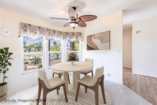 19703 Eagle Trace Ct, North Fort Myers, FL 33903 - dining room with a wainscoted wall, a ceiling fan, a textured ceiling, and a decorative wall