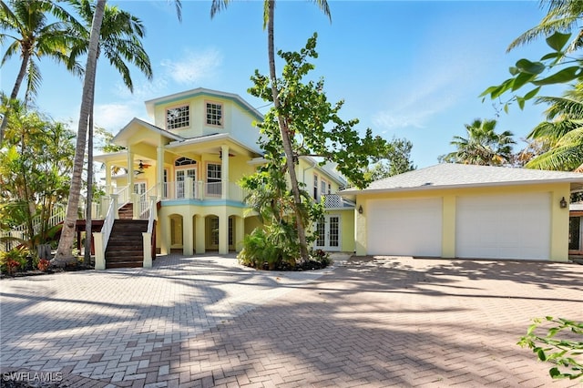 5697 Bay Point Rd, Bokeelia, FL 33922 - view of front of house with ceiling fan, stairway, stucco siding, decorative driveway, and french doors