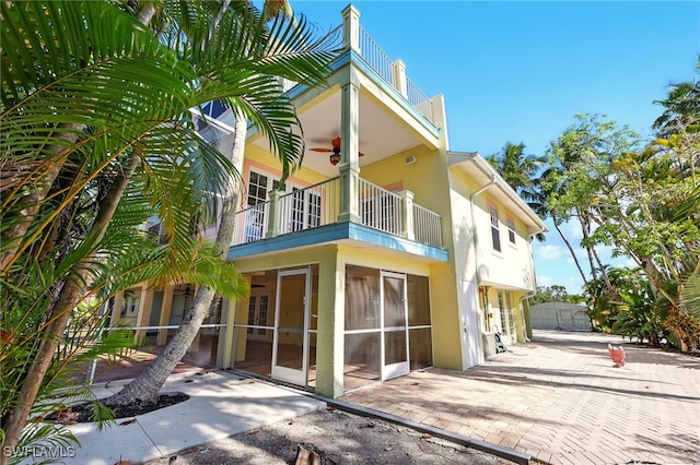 5697 Bay Point Rd, Bokeelia, FL 33922 - back of house featuring a balcony, stucco siding, ceiling fan, a patio, and french doors