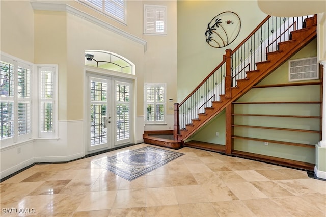 5697 Bay Point Rd, Bokeelia, FL 33922 - entrance foyer featuring stairway, french doors, a towering ceiling, and baseboards