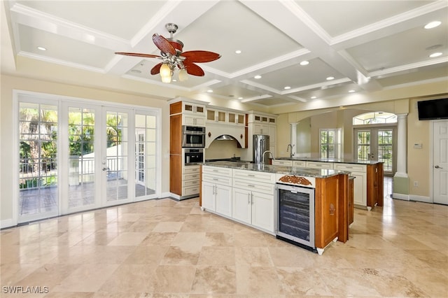 5697 Bay Point Rd, Bokeelia, FL 33922 - kitchen with wine cooler, coffered ceiling, french doors, a large island with sink, and a ceiling fan