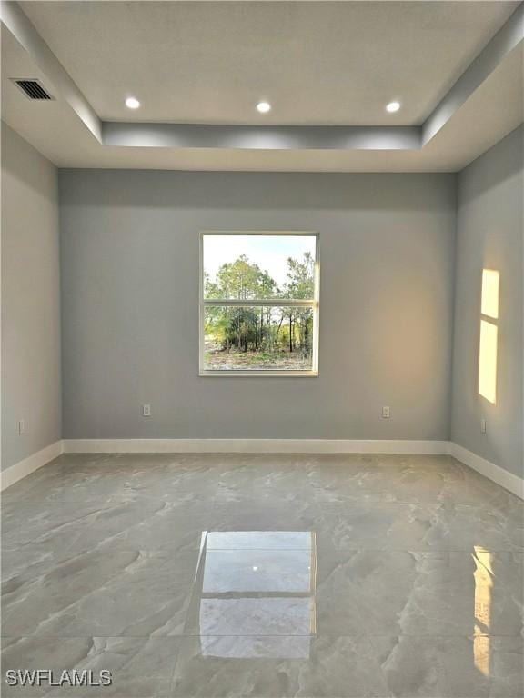 4391 66th Ave NE, Naples, FL 34120 - unfurnished room with a tray ceiling, plenty of natural light, concrete floors, baseboards, and recessed lighting