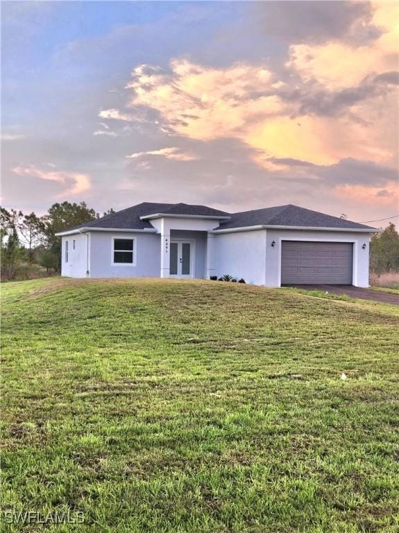 4391 66th Ave NE, Naples, FL 34120 - view of front of house featuring an attached garage, french doors, driveway, stucco siding, and a front lawn