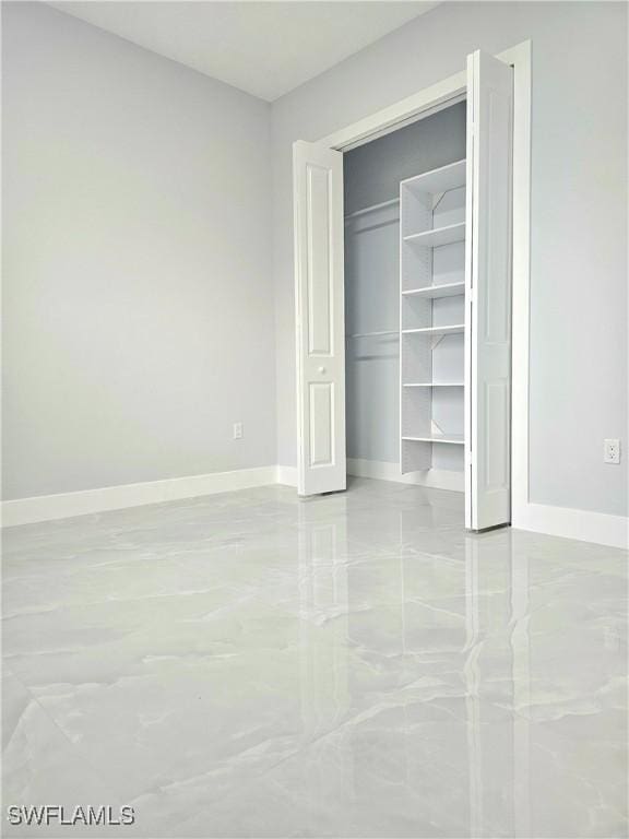 4391 66th Ave NE, Naples, FL 34120 - unfurnished bedroom featuring baseboards and a closet