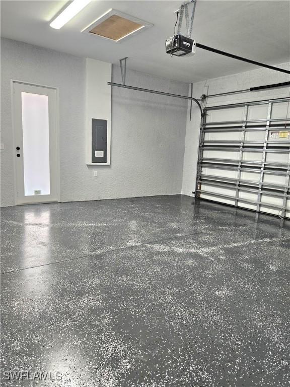 4391 66th Ave NE, Naples, FL 34120 - garage featuring a garage door opener, electric panel, and a textured wall