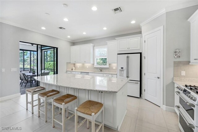 8396 Promoso Ct, Naples, FL 34114 - kitchen featuring high end fridge, double oven range, decorative backsplash, a kitchen island, and a breakfast bar