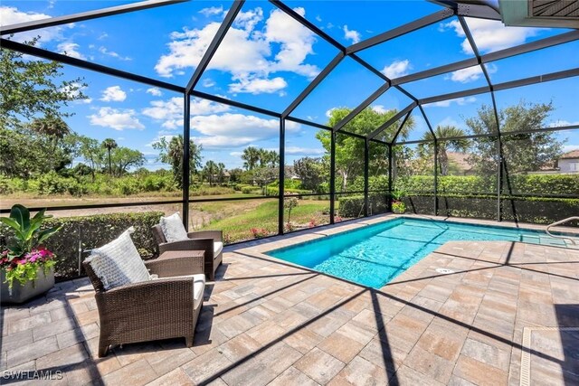 8396 Promoso Ct, Naples, FL 34114 - swimming pool featuring a patio, glass enclosure, and view of scattered trees