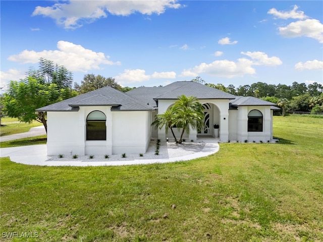 221 10th St SE, Naples, FL 34117 - french country home with a front lawn, stucco siding, and roof with shingles