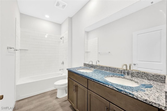 1414 NE 6th Ave, Cape Coral, FL 33909 - bathroom featuring wood finished floors, toilet, double vanity, and  shower combination