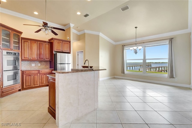 6140 River Shore Ct, North Fort Myers, FL 33917 - kitchen featuring appliances with stainless steel finishes, light tile patterned floors, stone countertops, tasteful backsplash, and crown molding