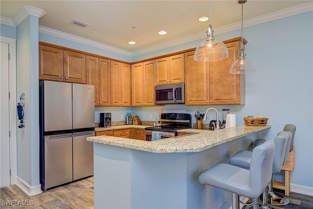 8163 Bibiana Way Unit 301, Fort Myers, FL 33912 - kitchen with appliances with stainless steel finishes, a peninsula, baseboards, light wood-style floors, and crown molding
