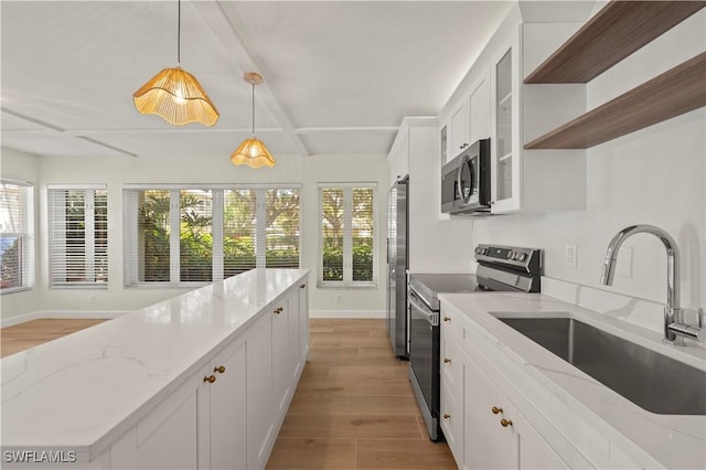 280 4th St S Unit 104, Naples, FL 34102 - kitchen with stainless steel appliances, a sink, light wood-style flooring, and baseboards