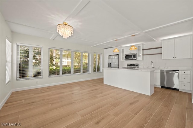 280 4th St S Unit 104, Naples, FL 34102 - kitchen featuring stainless steel appliances, a chandelier, healthy amount of natural light, and white cabinetry